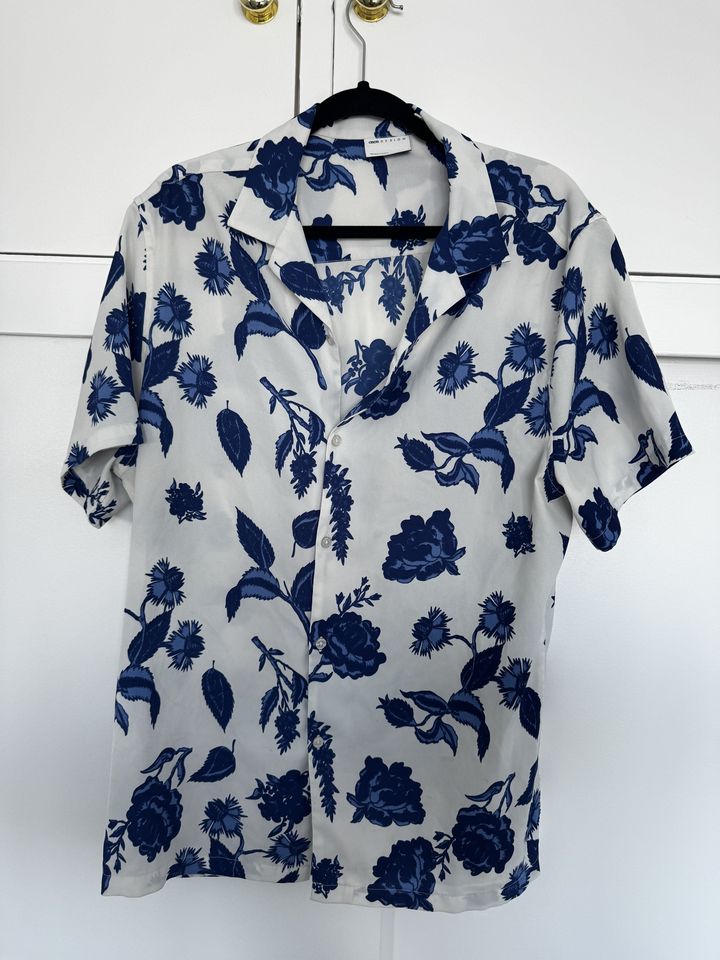 ASOS DESIGN white short-sleeve shirt with navy floral print, front view on a hanger